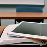An ipad resting on an open book