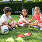 Three children sat on grass