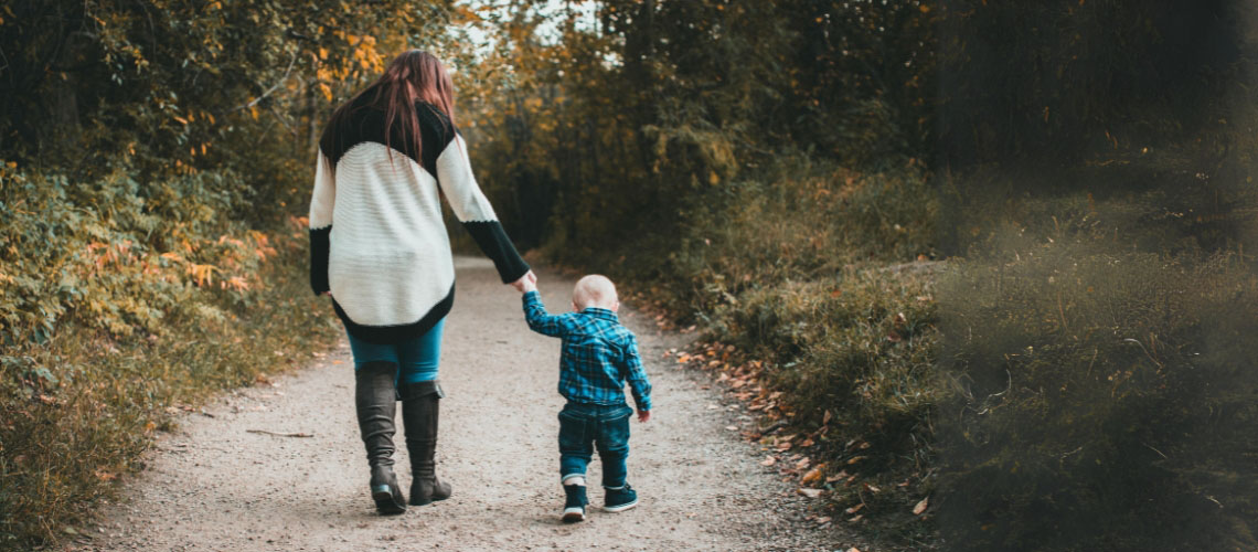 Mother and toddler walkng down a path