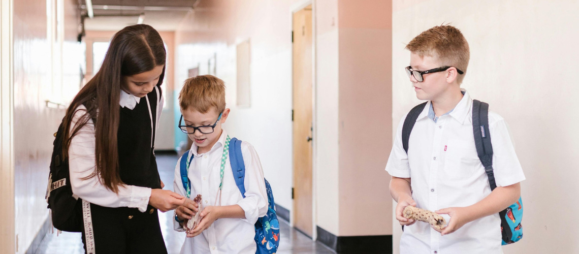 THree school children in a corridor