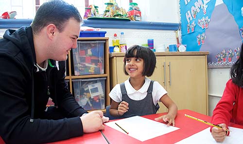 Teacher and young girl learning maths in classroom