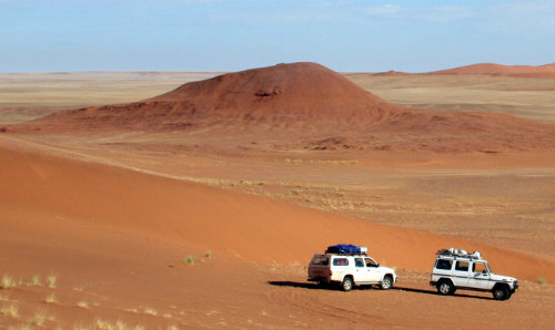 Two land rovers in a desert