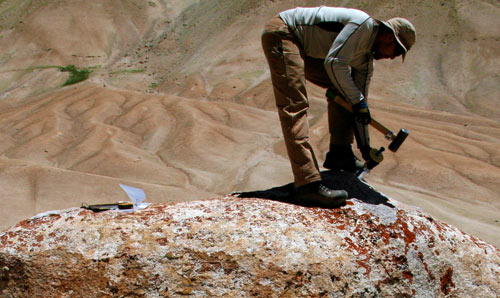 PhD researcher taking a rock sample
