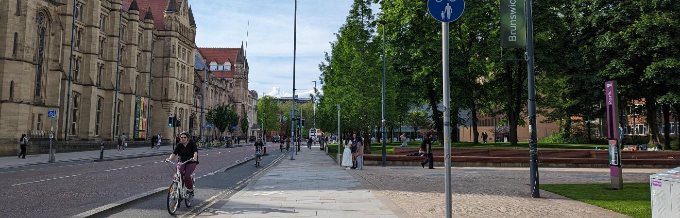 Street view of Oxford Road in Manchester showing pedestrians walking past the Whitworth building.