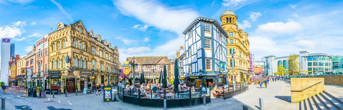 Restaurants full of people on the Shambles square in Manchester, England.