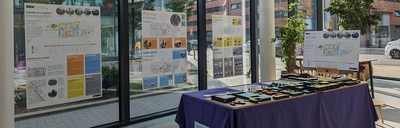 Urban planning exhibition with posters and campus model at Manchester Alliance Business School.