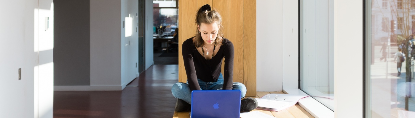 A PGR student typing at laptop