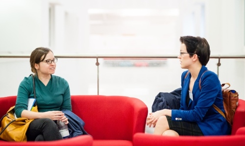 two students chatting on a sofa