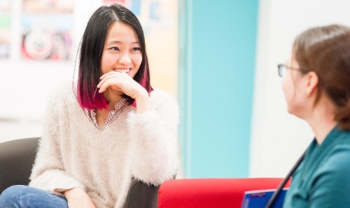 Two students chatting looking happy